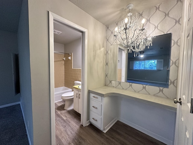 full bathroom featuring vanity, a chandelier, hardwood / wood-style floors, toilet, and tiled shower / bath