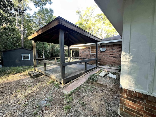 view of patio / terrace featuring a wooden deck and a storage shed