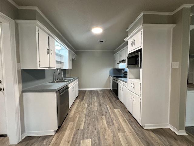 kitchen with white cabinets, appliances with stainless steel finishes, hardwood / wood-style floors, and sink