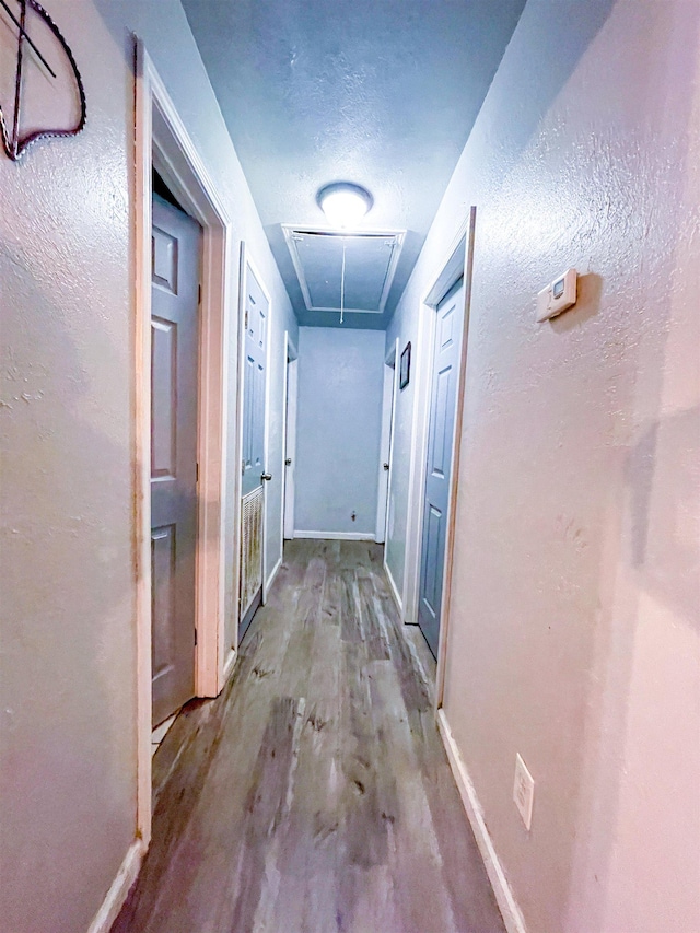 hall with light hardwood / wood-style floors and a textured ceiling