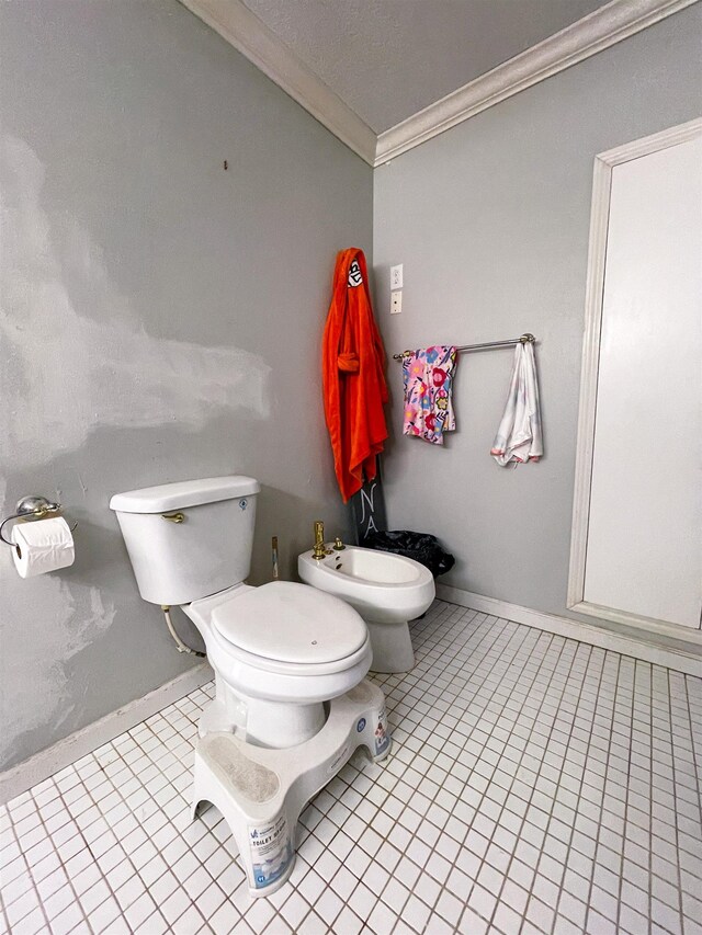 bathroom with tile patterned floors, toilet, crown molding, and a bidet