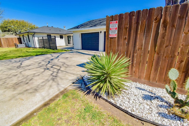 view of front facade with a front yard, fence, a garage, and driveway