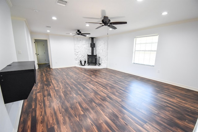 unfurnished living room with recessed lighting, visible vents, dark wood-type flooring, and a wood stove