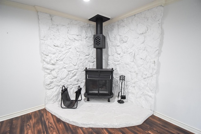 interior details featuring baseboards, wood finished floors, a wood stove, and ornamental molding