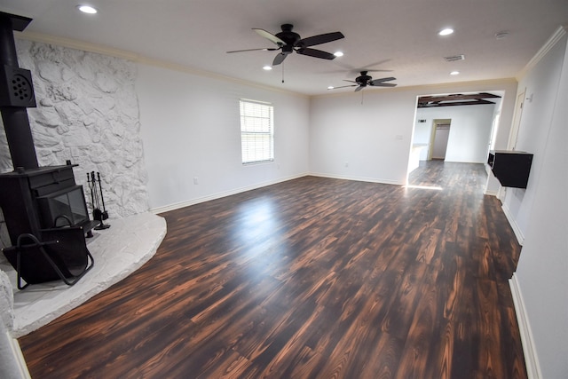 unfurnished living room featuring a ceiling fan, wood finished floors, a wood stove, and crown molding