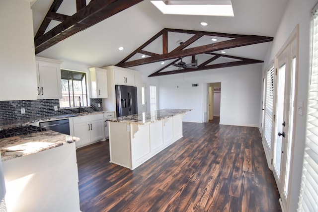 kitchen featuring lofted ceiling with beams, dark wood-style floors, appliances with stainless steel finishes, and a kitchen island