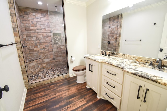 full bath featuring a stall shower, wood finished floors, crown molding, and a sink