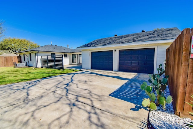 ranch-style home featuring an outdoor structure, a front lawn, a garage, and fence