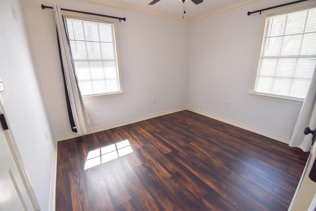 empty room with dark wood finished floors, baseboards, a ceiling fan, and ornamental molding