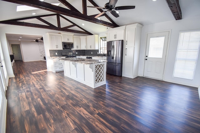 kitchen with a breakfast bar, decorative backsplash, appliances with stainless steel finishes, dark wood-style floors, and a ceiling fan