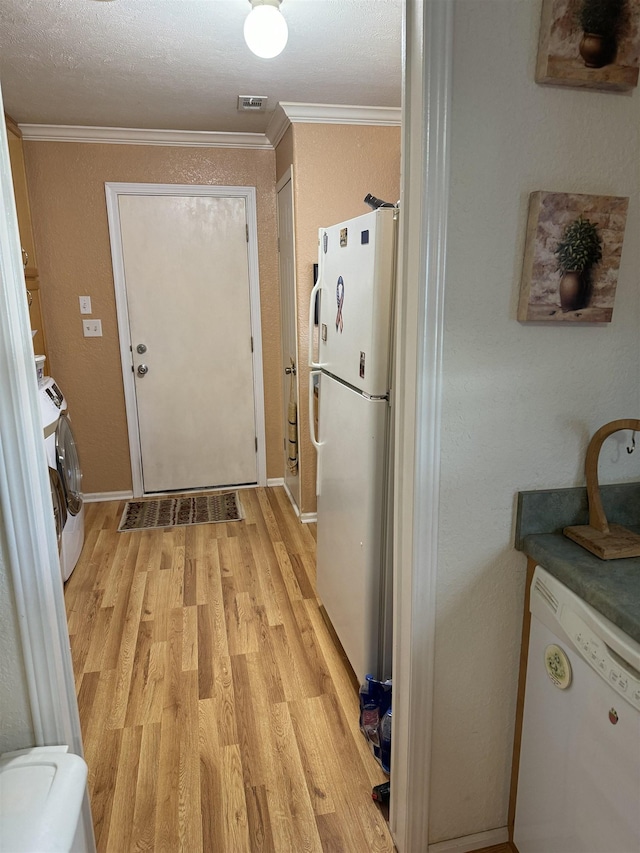 kitchen featuring ornamental molding, light wood-type flooring, white appliances, and washer / dryer