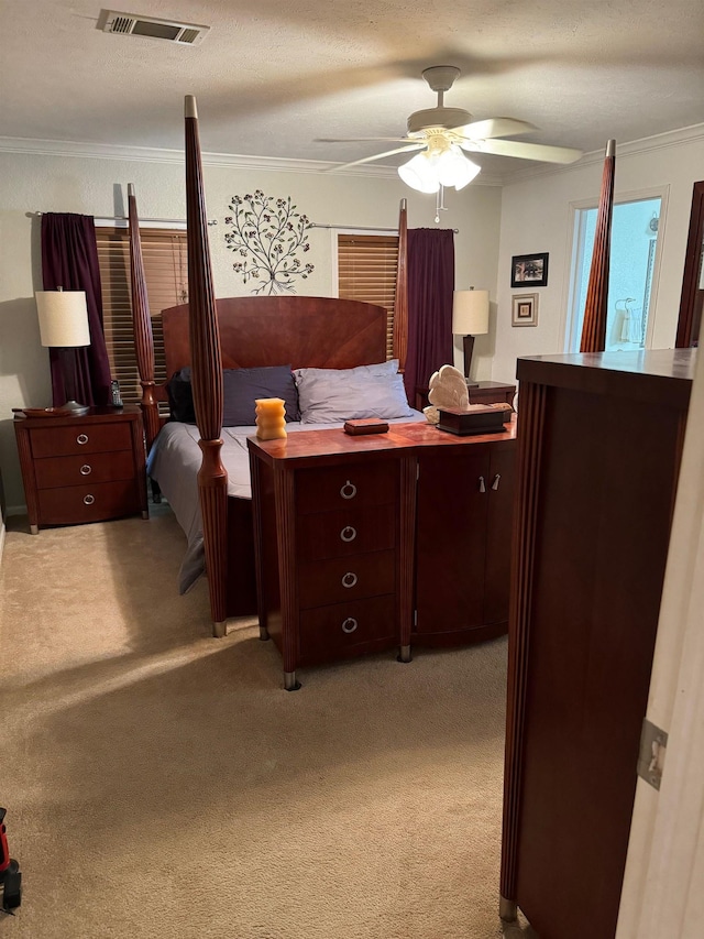 bedroom featuring ceiling fan, ornamental molding, a textured ceiling, and light carpet