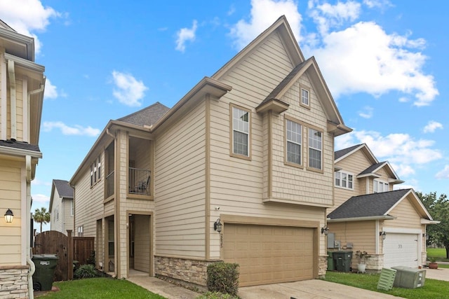 2635 Cedar Spgs, Port Arthur, TX 77630 - view of front facade with fence, stone siding, an attached garage, and a balcony