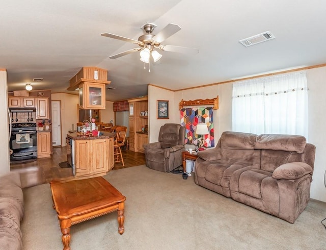 carpeted living room with ceiling fan, crown molding, and lofted ceiling