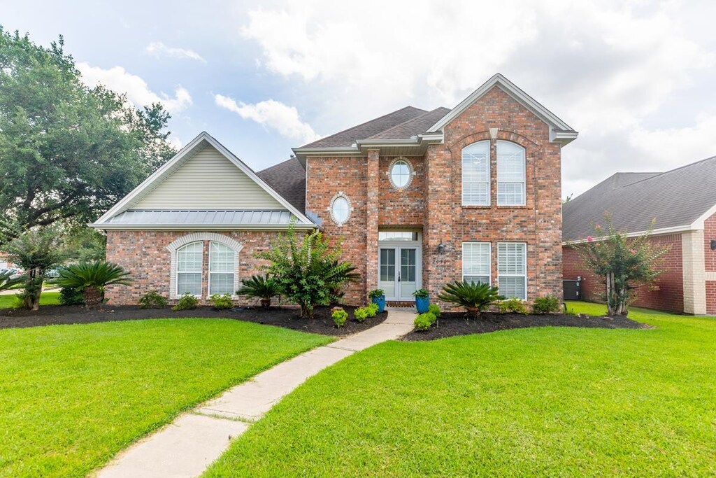 2030 Rosewood St, Beaumont, TX 77713 - view of front of property featuring a front yard, brick siding, and a metal roof