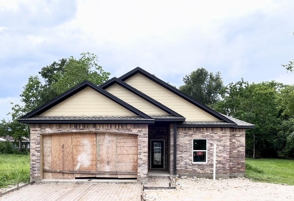 3520 Pradice St, Beaumont, TX 77705 - single story home featuring an attached garage, brick siding, and decorative driveway