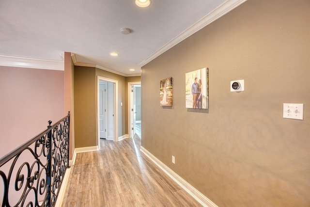 hallway featuring ornamental molding and light hardwood / wood-style flooring