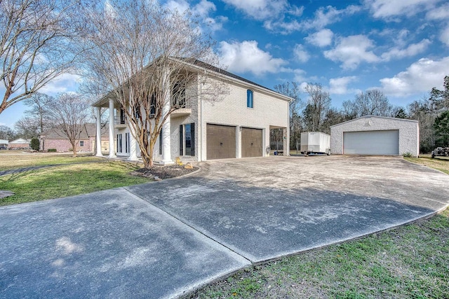 view of front of property with an outbuilding, a garage, and a front lawn