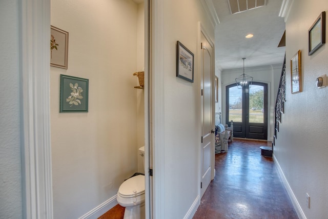 interior space with an inviting chandelier, crown molding, and french doors