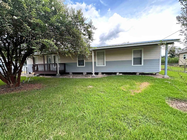 rear view of house featuring a yard