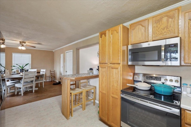 595 Blanton Pl, Beaumont, TX 77707 - kitchen featuring appliances with stainless steel finishes, ceiling fan, ornamental molding, a textured ceiling, and light countertops