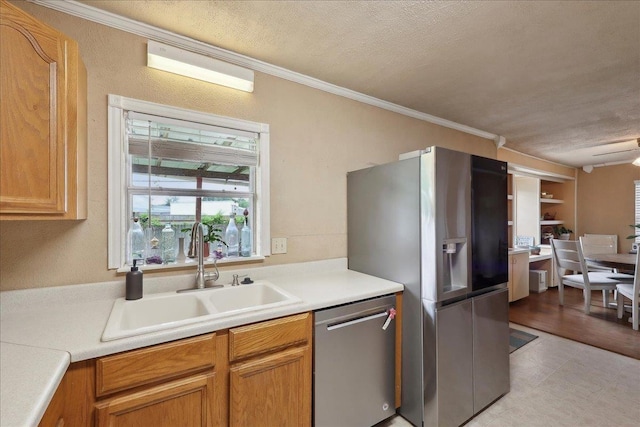 595 Blanton Pl, Beaumont, TX 77707 - kitchen featuring stainless steel appliances, a sink, crown molding, light countertops, and a textured ceiling