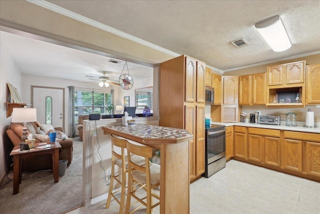 595 Blanton Pl, Beaumont, TX 77707 - kitchen featuring stainless steel appliances, light countertops, ornamental molding, a ceiling fan, and open floor plan