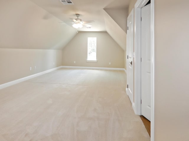 additional living space featuring lofted ceiling, baseboards, visible vents, and light colored carpet