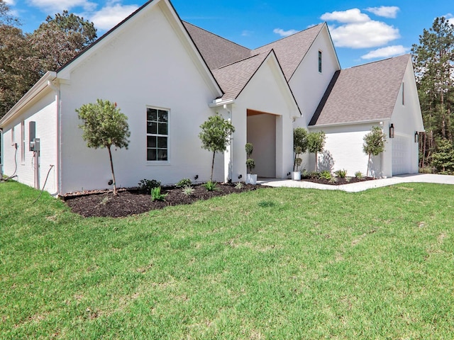 view of front facade featuring a garage, a shingled roof, a front lawn, and stucco siding