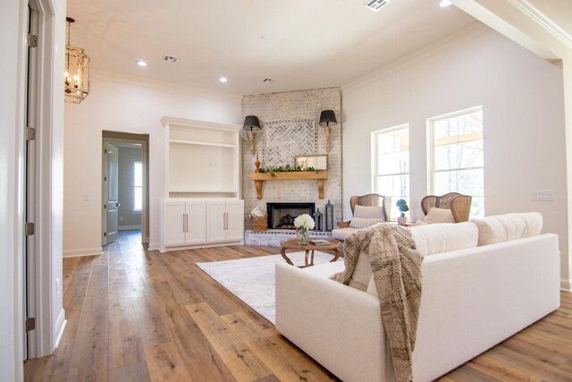 unfurnished living room with hardwood / wood-style floors, ornamental molding, and a fireplace