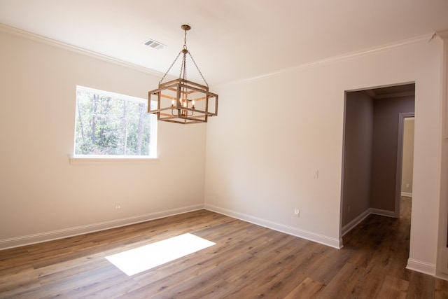 unfurnished room with a chandelier, crown molding, and dark wood-type flooring