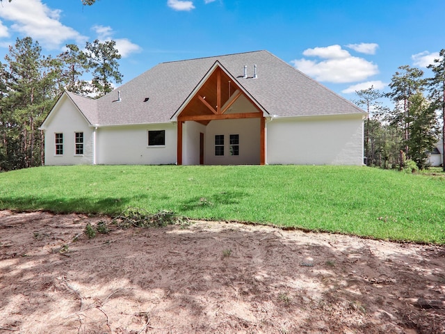 view of front facade featuring a shingled roof and a front lawn