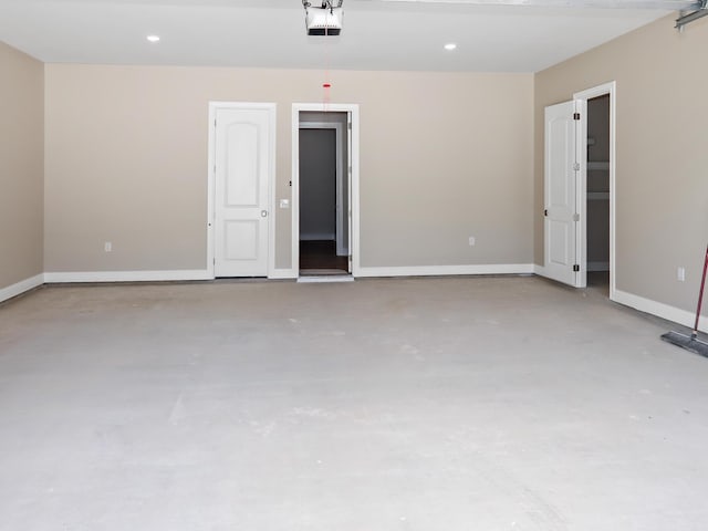 garage featuring a garage door opener, recessed lighting, and baseboards