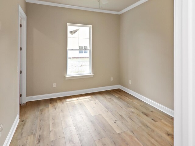 spare room featuring light wood finished floors, ceiling fan, baseboards, and ornamental molding