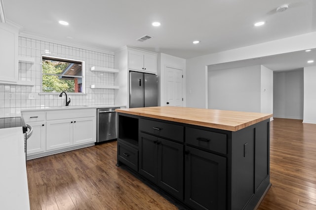 kitchen featuring appliances with stainless steel finishes, wood counters, visible vents, and white cabinetry