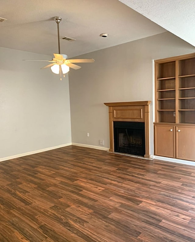 unfurnished living room with dark wood-style flooring, a fireplace, visible vents, ceiling fan, and baseboards