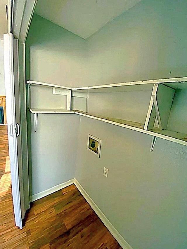 clothes washing area featuring dark wood-style floors, baseboards, and washer hookup