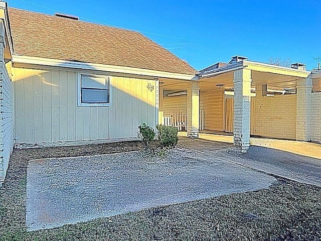 exterior space featuring roof with shingles