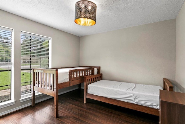 bedroom featuring dark hardwood / wood-style floors and a textured ceiling