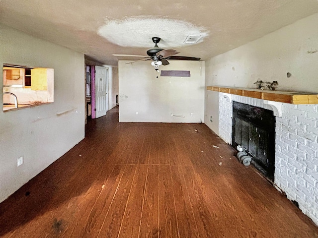 unfurnished living room with a textured ceiling, ceiling fan, and dark hardwood / wood-style floors