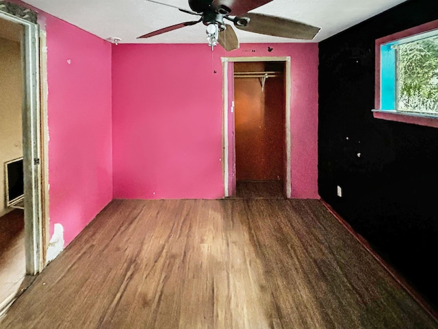 unfurnished bedroom with ceiling fan, wood-type flooring, and a closet