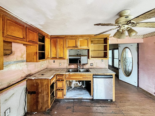 kitchen featuring dishwasher, backsplash, sink, ceiling fan, and tile counters