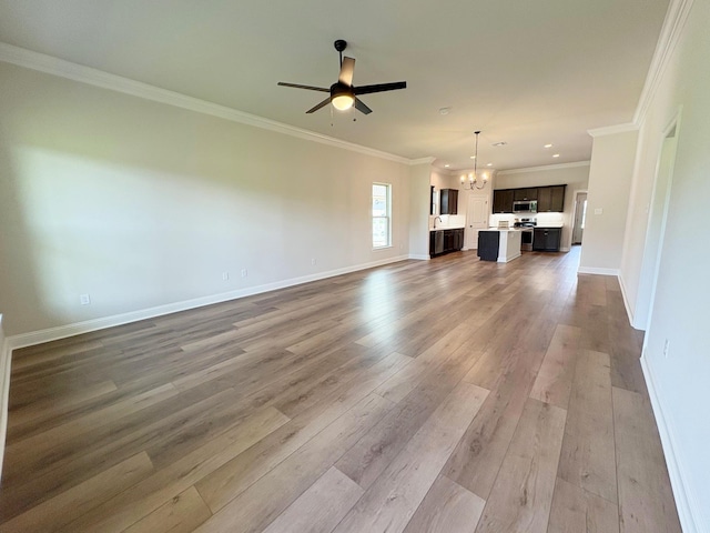 1240 Little Cypress Loop, Orange, TX 77632 - unfurnished living room featuring a chandelier, a ceiling fan, wood finished floors, ornamental molding, and baseboards