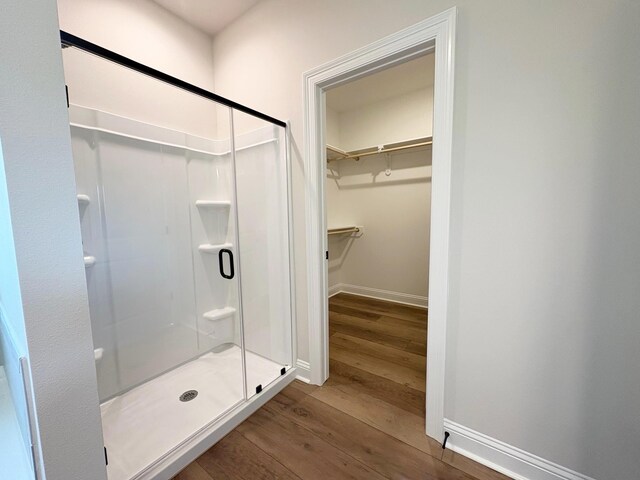 1240 Little Cypress Loop, Orange, TX 77632 - bathroom with wood finished floors, a shower stall, a spacious closet, and baseboards