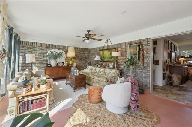living area featuring a ceiling fan, brick wall, and visible vents