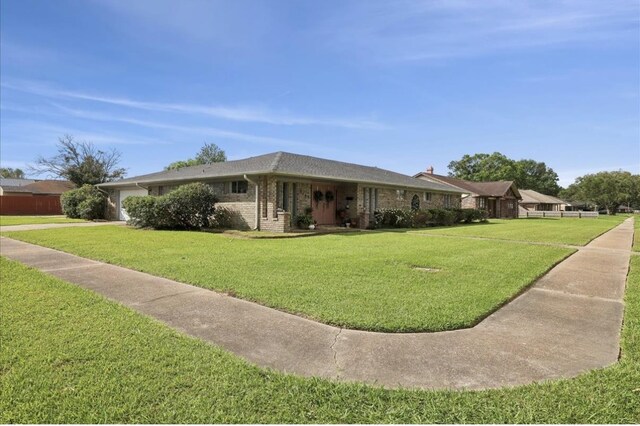 view of front of property with brick siding, a garage, driveway, and a front yard