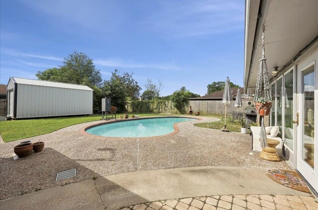 view of pool featuring a fenced in pool, an outdoor structure, a fenced backyard, a yard, and a patio