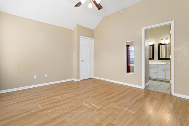 unfurnished bedroom with ceiling fan, lofted ceiling, ensuite bathroom, and light hardwood / wood-style flooring