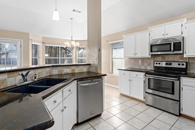 kitchen featuring light tile patterned flooring, appliances with stainless steel finishes, decorative light fixtures, white cabinetry, and sink