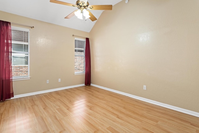 empty room featuring ceiling fan, plenty of natural light, light hardwood / wood-style floors, and vaulted ceiling